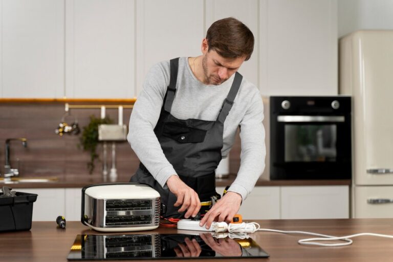 A man in an apron cutting cake on top of a stove.