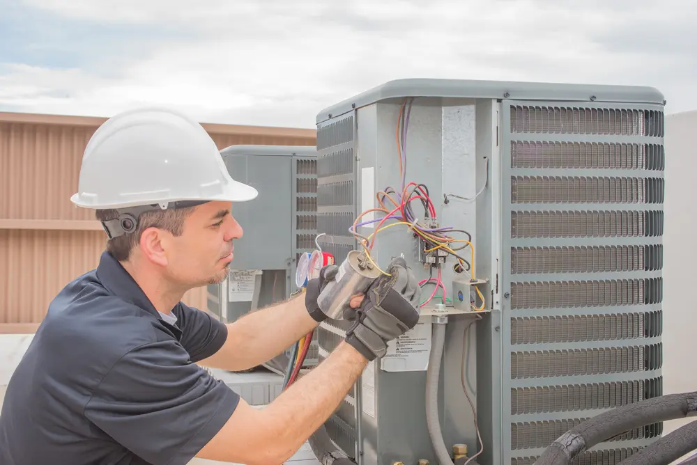 A man working on an air conditioner unit.