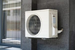 A white air conditioner mounted on the side of a building.