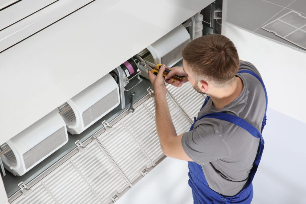 A man working on an air conditioner unit.