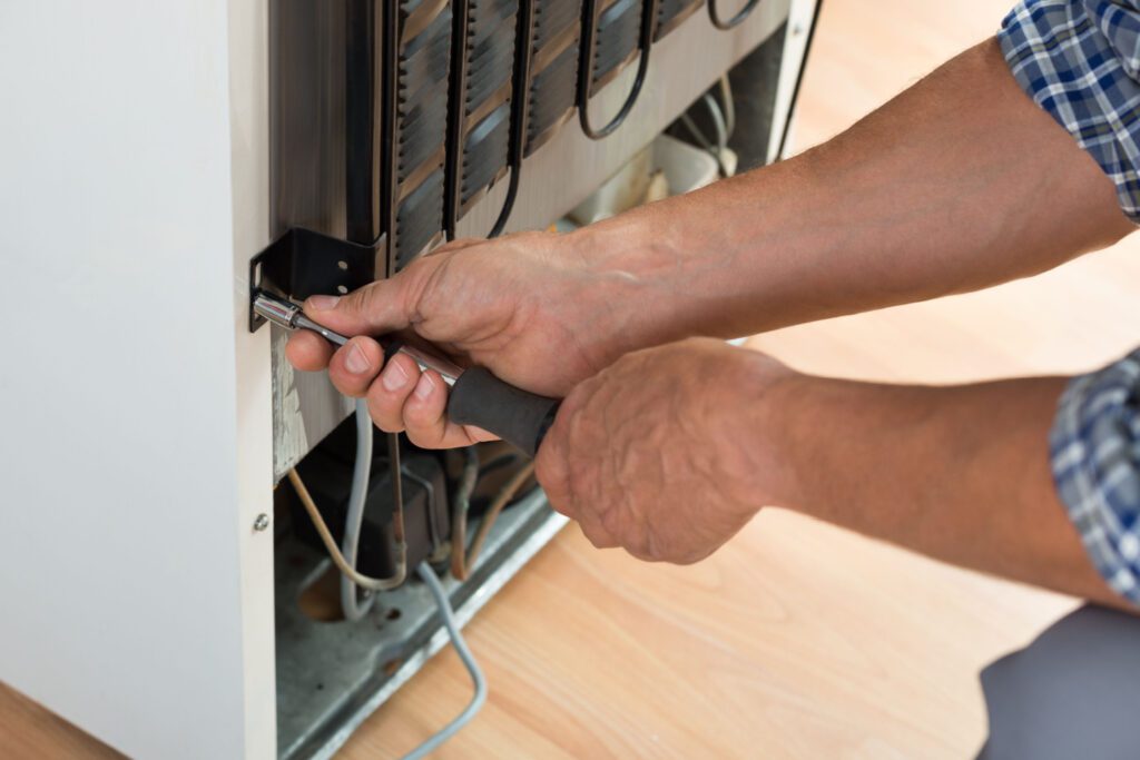 A person is working on the inside of an appliance.